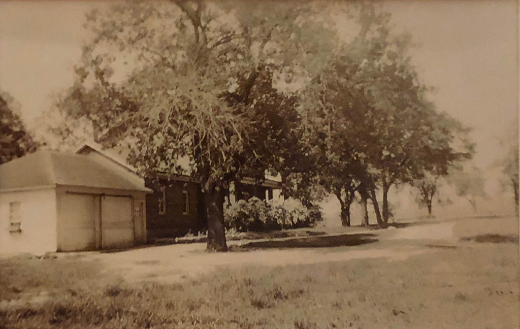 Cream brick famhouse and garage ca. 1930s